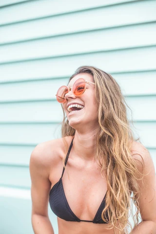 Microdosing cannabis edibles: Happy woman in swimsuit with sunglasses during the summer