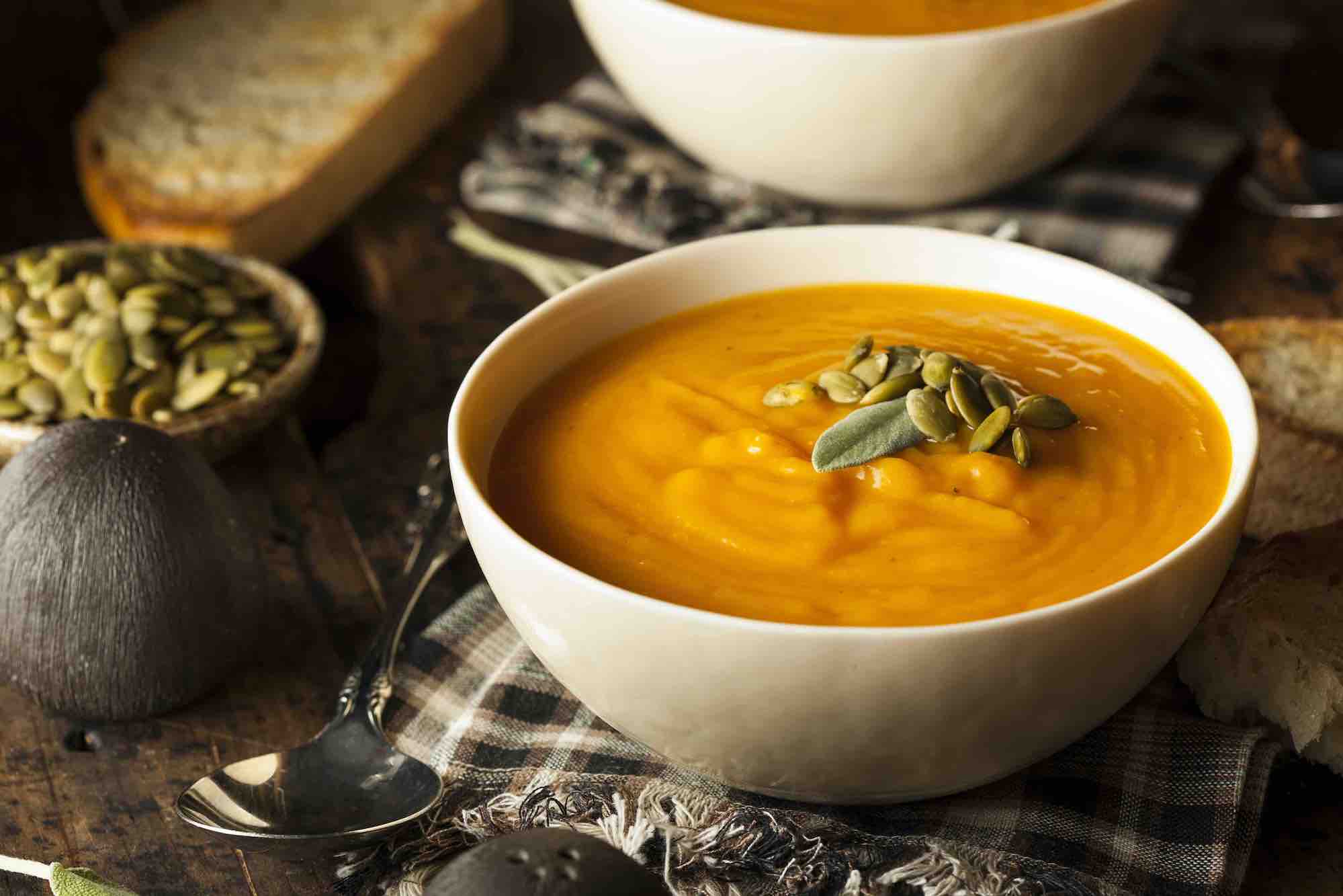 White bowl of spiced butternut squash soup with parsley garnish